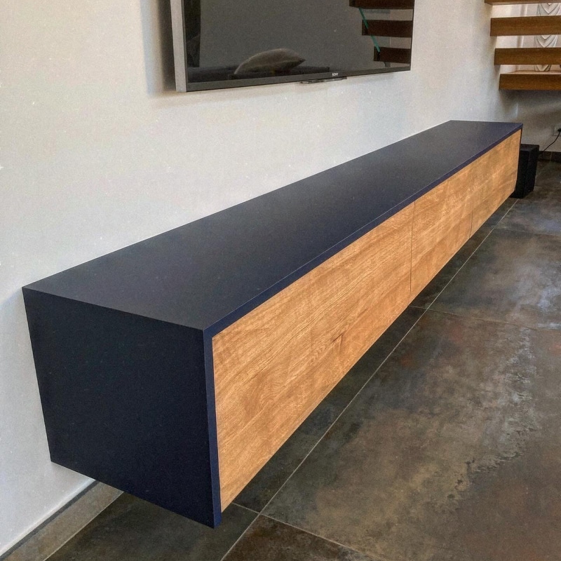 Meuble TV Flottant Bois et Bleu Nuit Moderne Meuble TV flottant minimaliste avec plateau bleu nuit et façades en bois clair, sous un téléviseur mural.